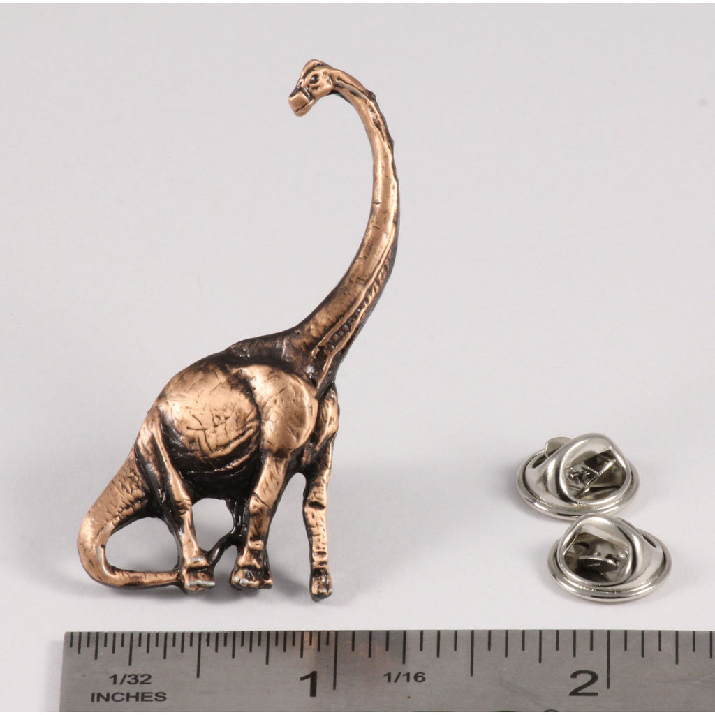 A handcrafted Brontosaurus Pin next to a ruler, available for sale at Creativeartisan.com - the image offers a sense of scale