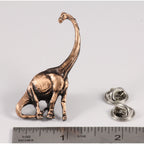A handcrafted Brontosaurus Pin next to a ruler, available for sale at Creativeartisan.com - the image offers a sense of scale