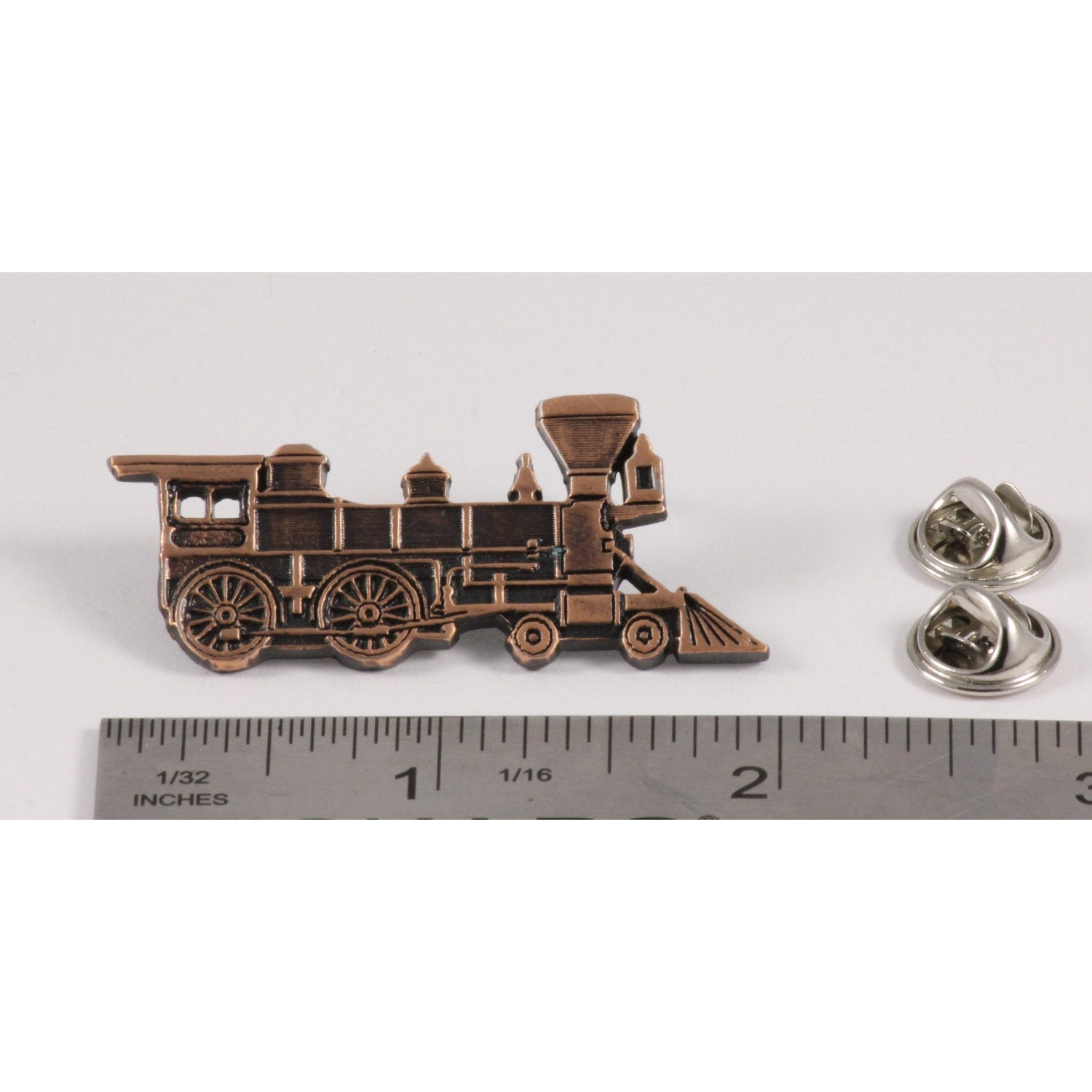 A handcrafted Train Engine Pin next to a ruler, available for sale at Creativeartisan.com - the image offers a sense of scale