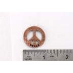 A handcrafted Peace Imprinted With Peace Pin next to a ruler, available for sale at Creativeartisan.com - the image offers a sense of scale