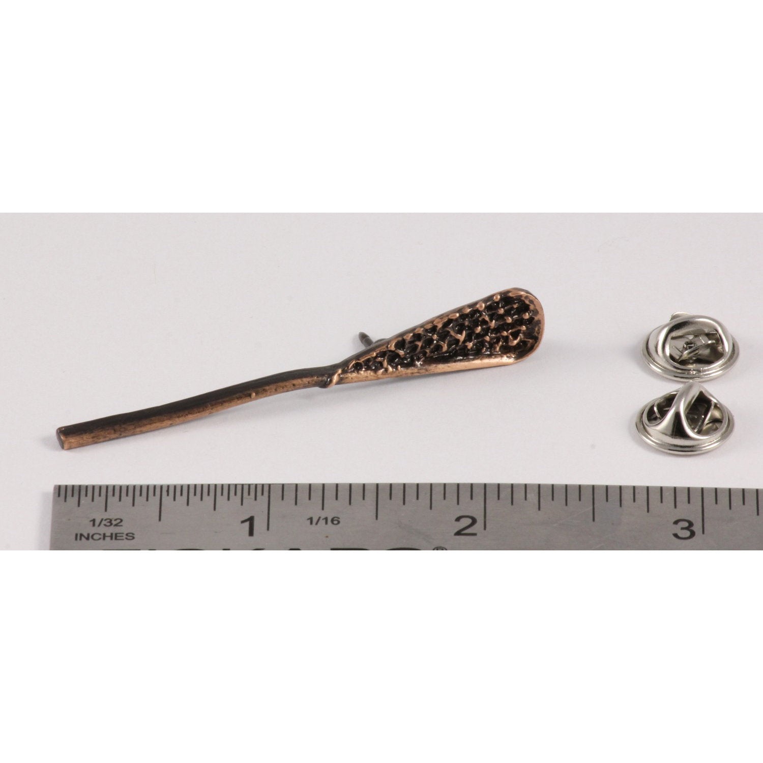 A handcrafted La Crosse Native Stick Pin next to a ruler, available for sale at Creativeartisan.com - the image offers a sense of scale