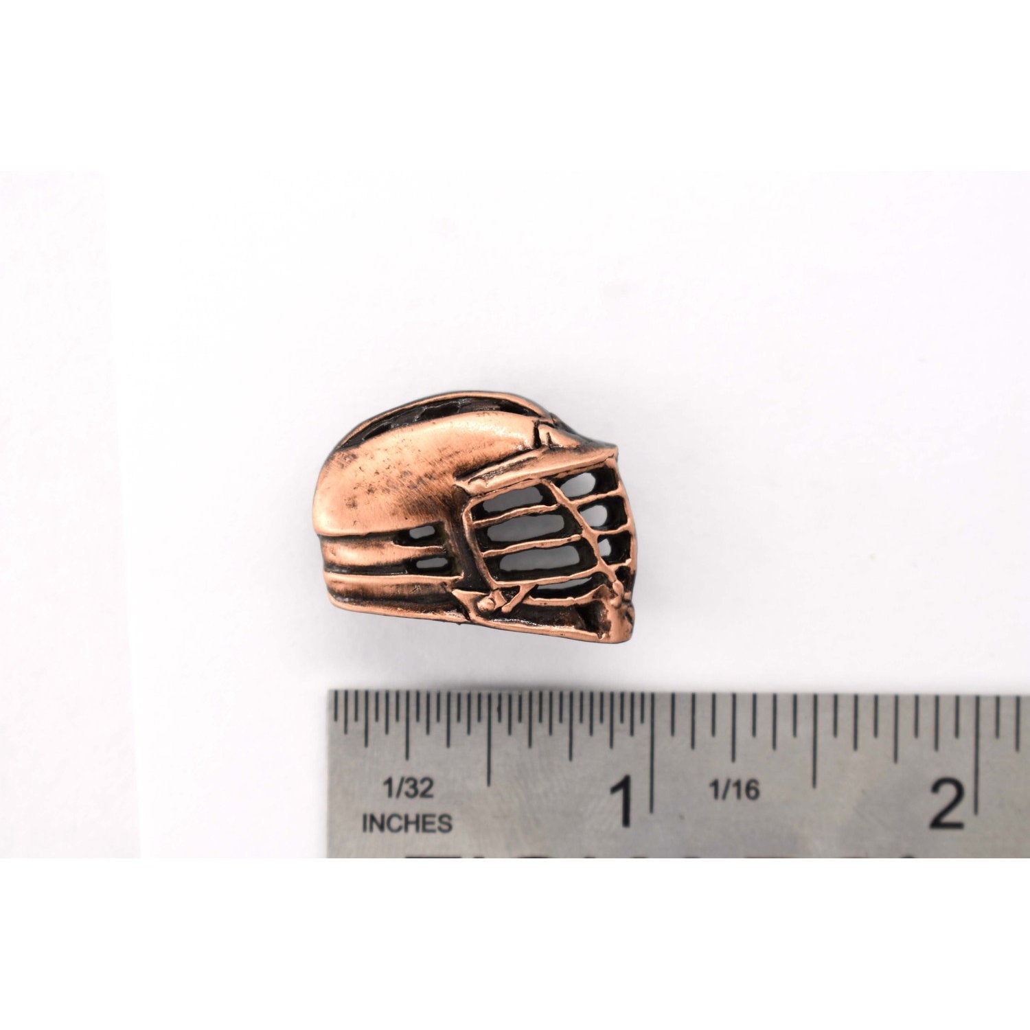 A handcrafted La Crosse Helmet Pin next to a ruler, available for sale at Creativeartisan.com - the image offers a sense of scale