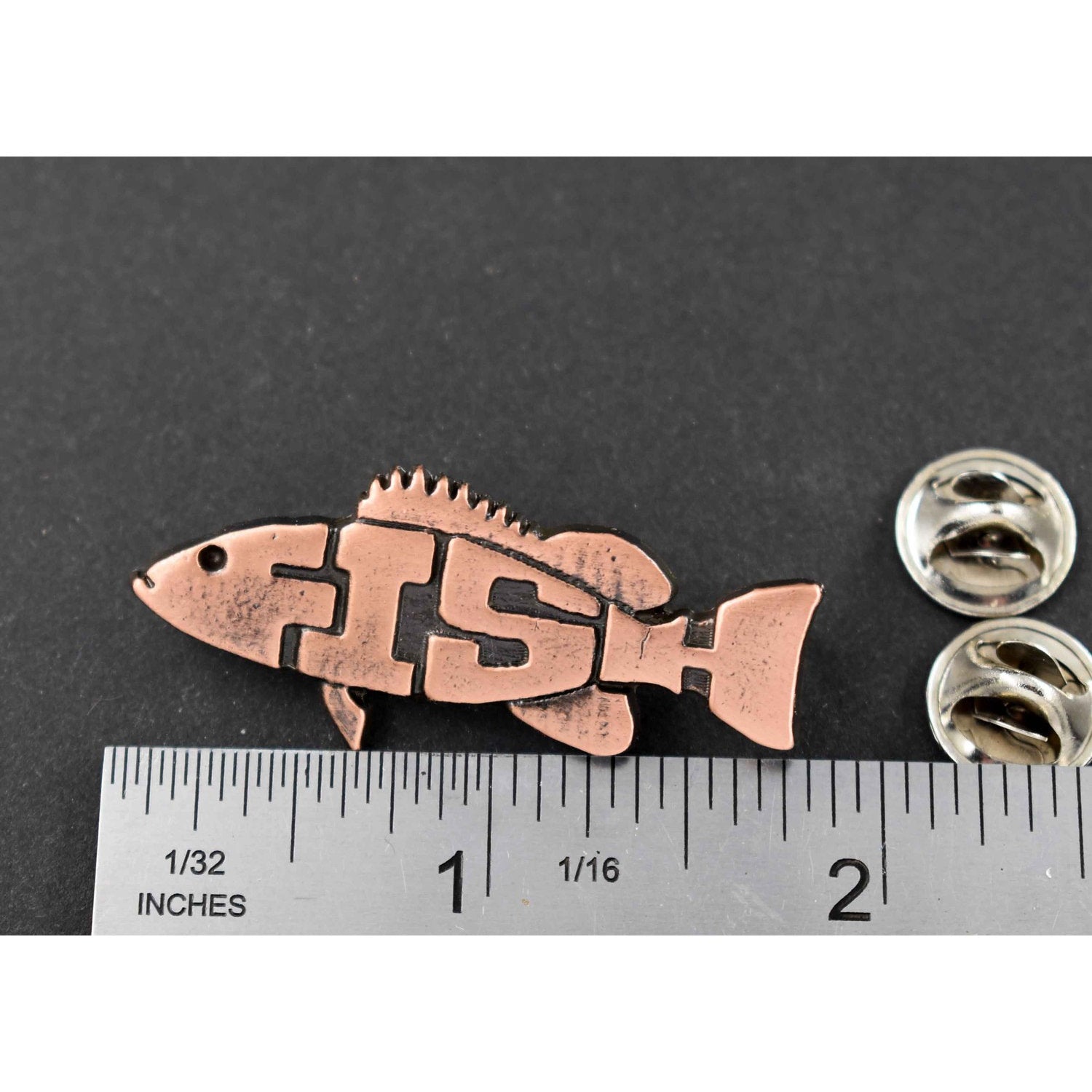 A handcrafted Angel Fish Pin Spelled Out next to a ruler, available for sale at Creativeartisan.com - the image offers a sense of scale