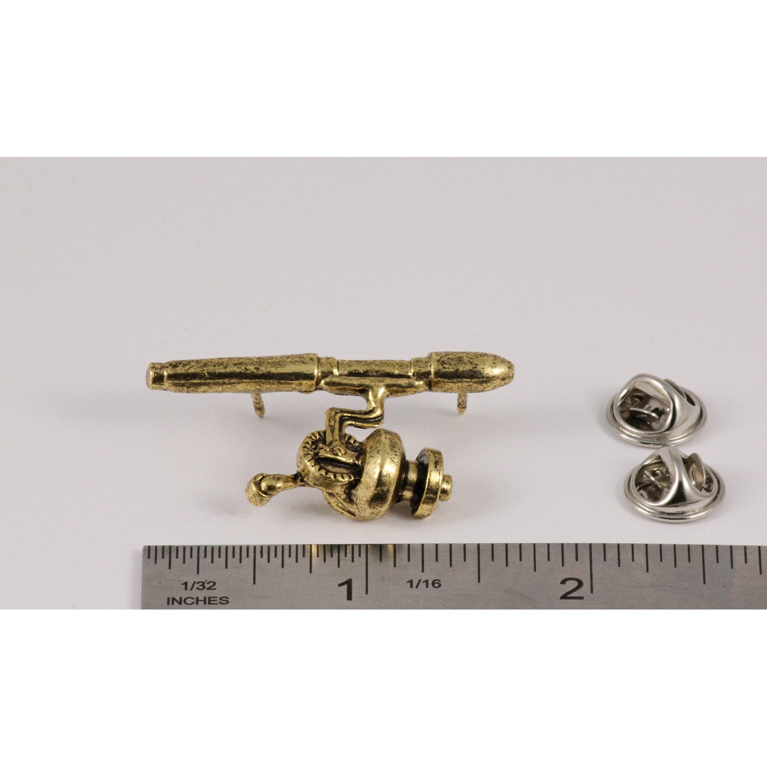 A handcrafted Spinning Rod Reel Pin next to a ruler, available for sale at Creativeartisan.com - the image offers a sense of scale