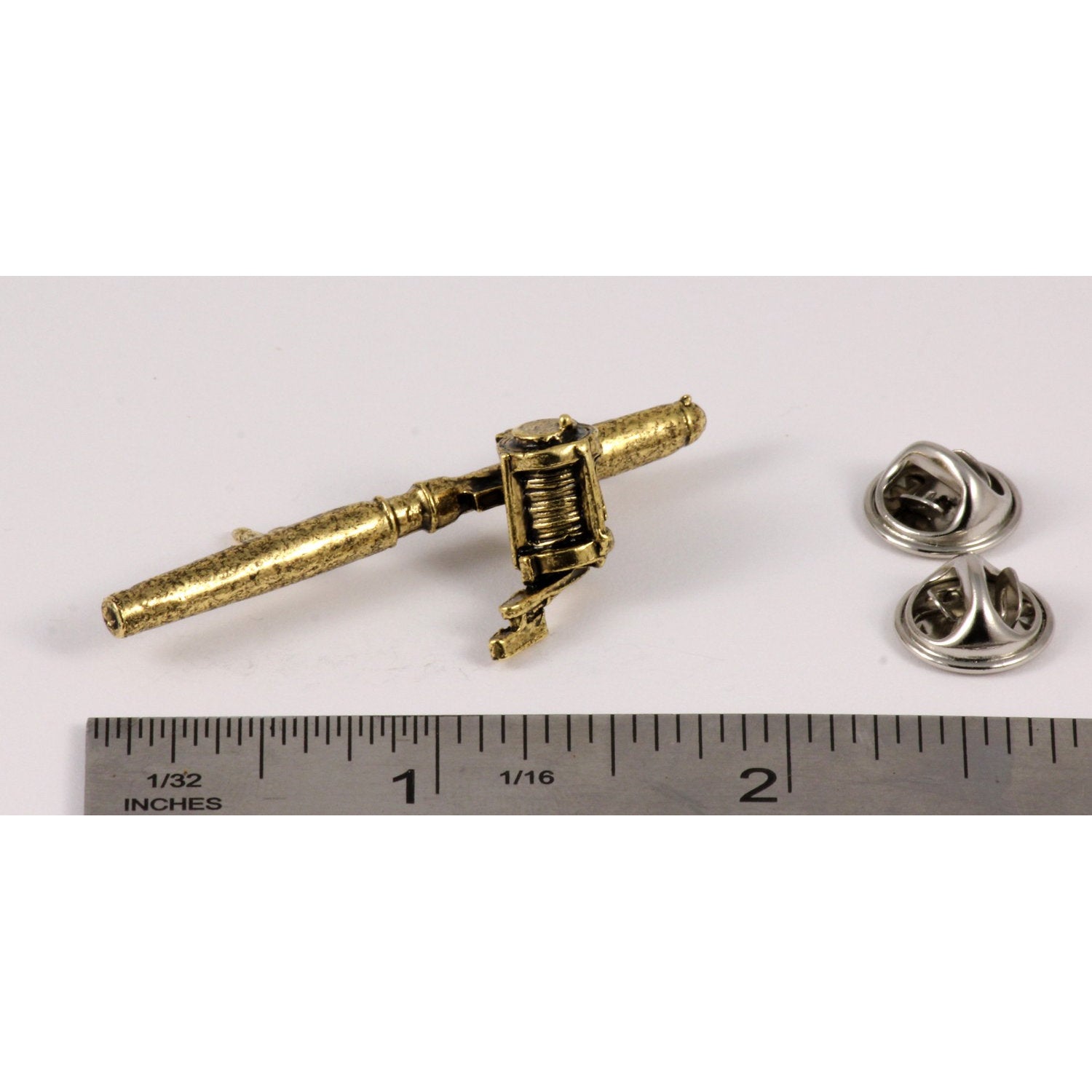 A handcrafted Bait Casting Rod Reel Pin next to a ruler, available for sale at Creativeartisan.com - the image offers a sense of scale