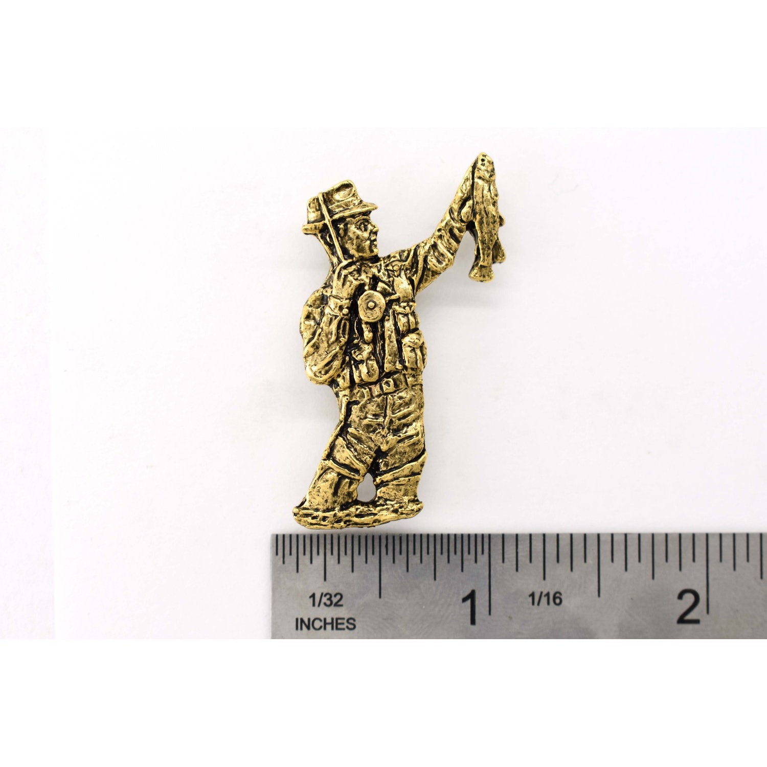 A handcrafted Fly Fisherman Pin next to a ruler, available for sale at Creativeartisan.com - the image offers a sense of scale
