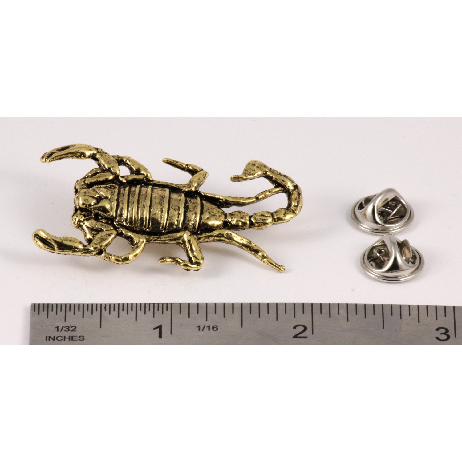 A handcrafted Scorpion Pin next to a ruler, available for sale at Creativeartisan.com - the image offers a sense of scale