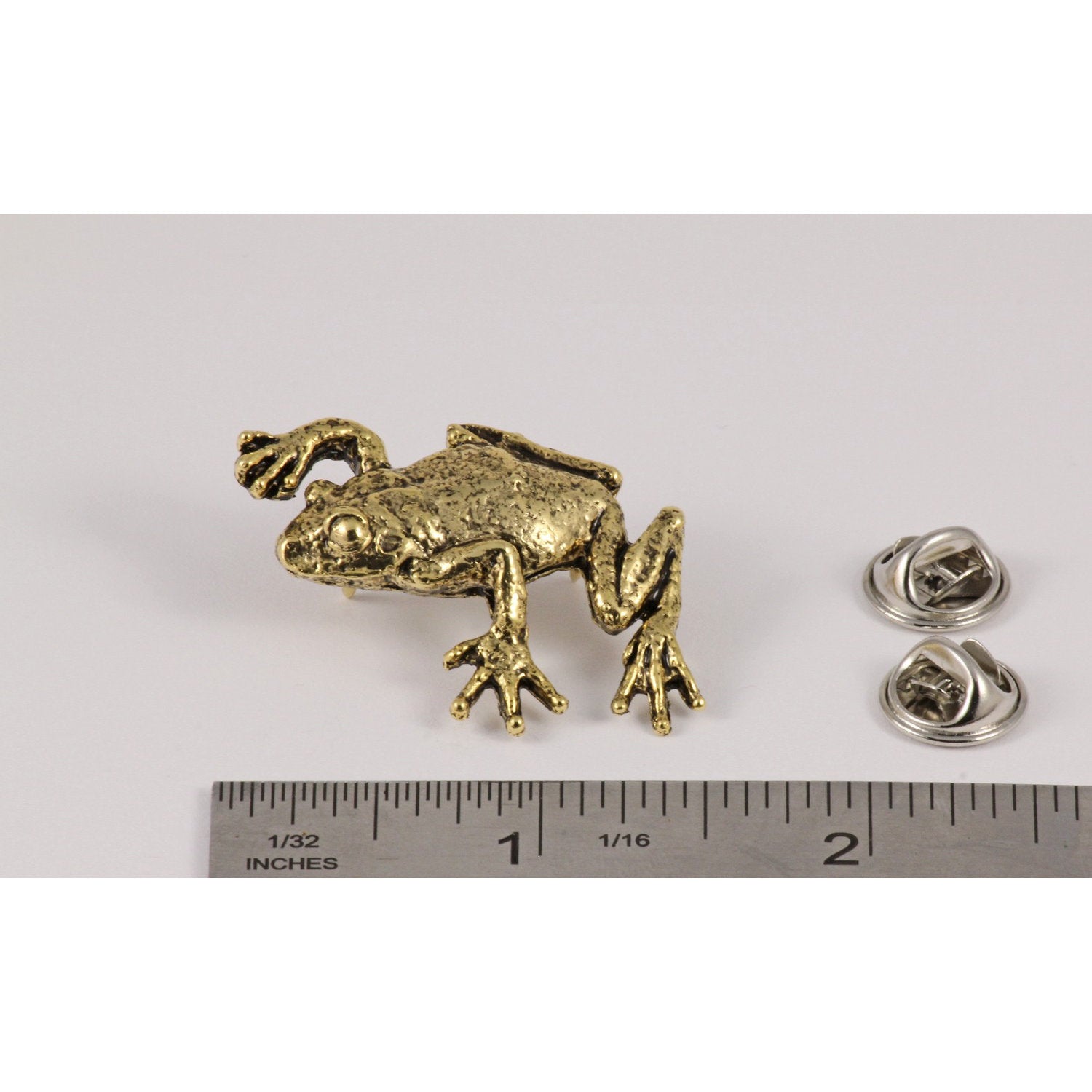 A handcrafted Tree Frog Climbing Pin next to a ruler, available for sale at Creativeartisan.com - the image offers a sense of scale