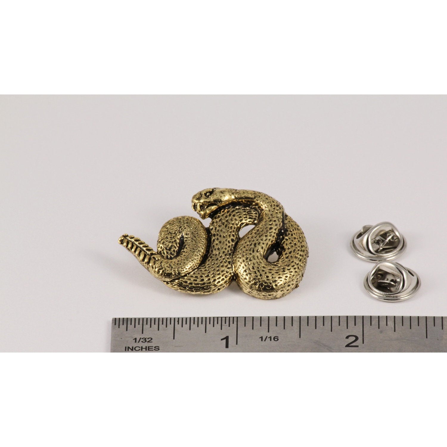 A handcrafted Rattlesnake Pin next to a ruler, available for sale at Creativeartisan.com - the image offers a sense of scale
