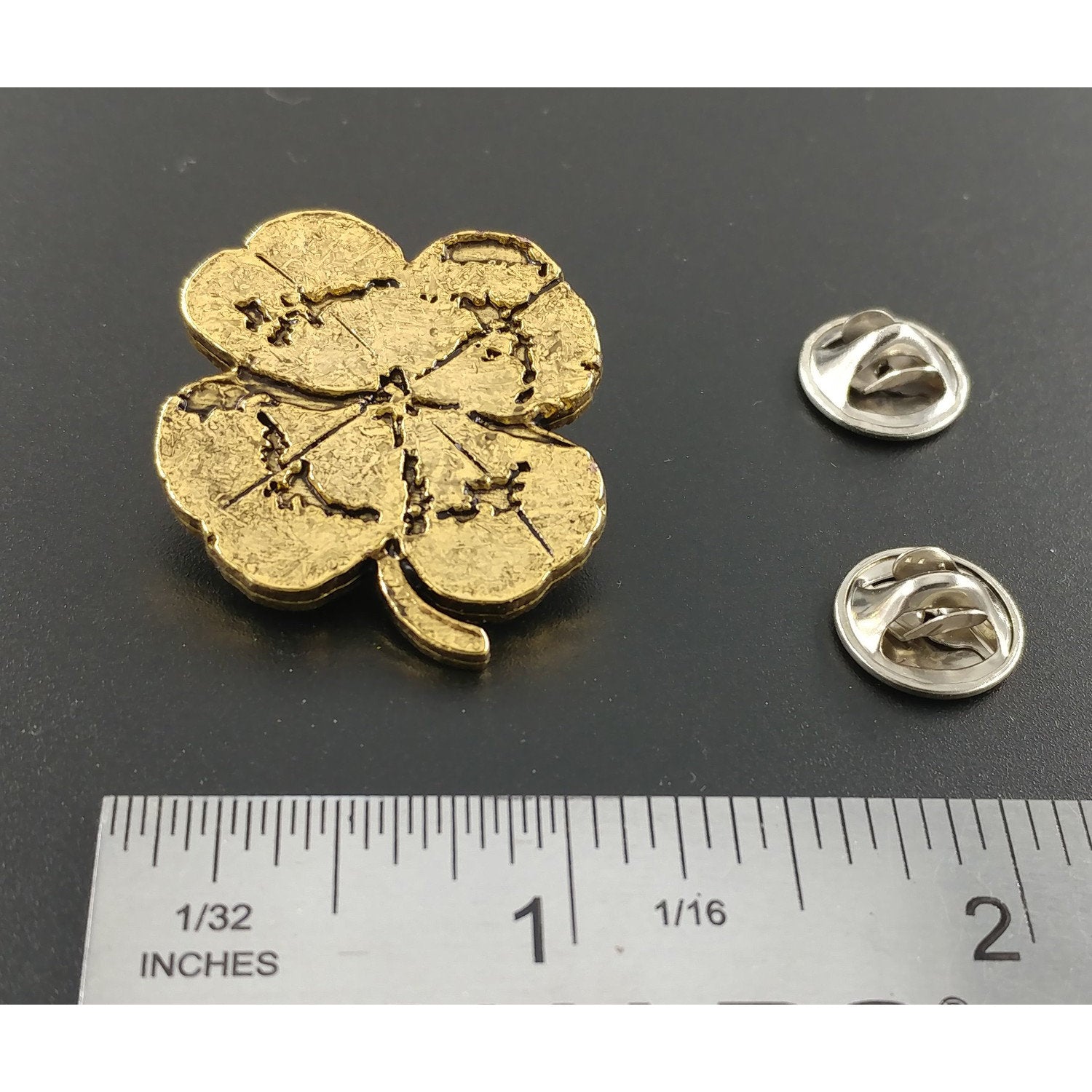 A handcrafted Four Leaf Clover Pin next to a ruler, available for sale at Creativeartisan.com - the image offers a sense of scale
