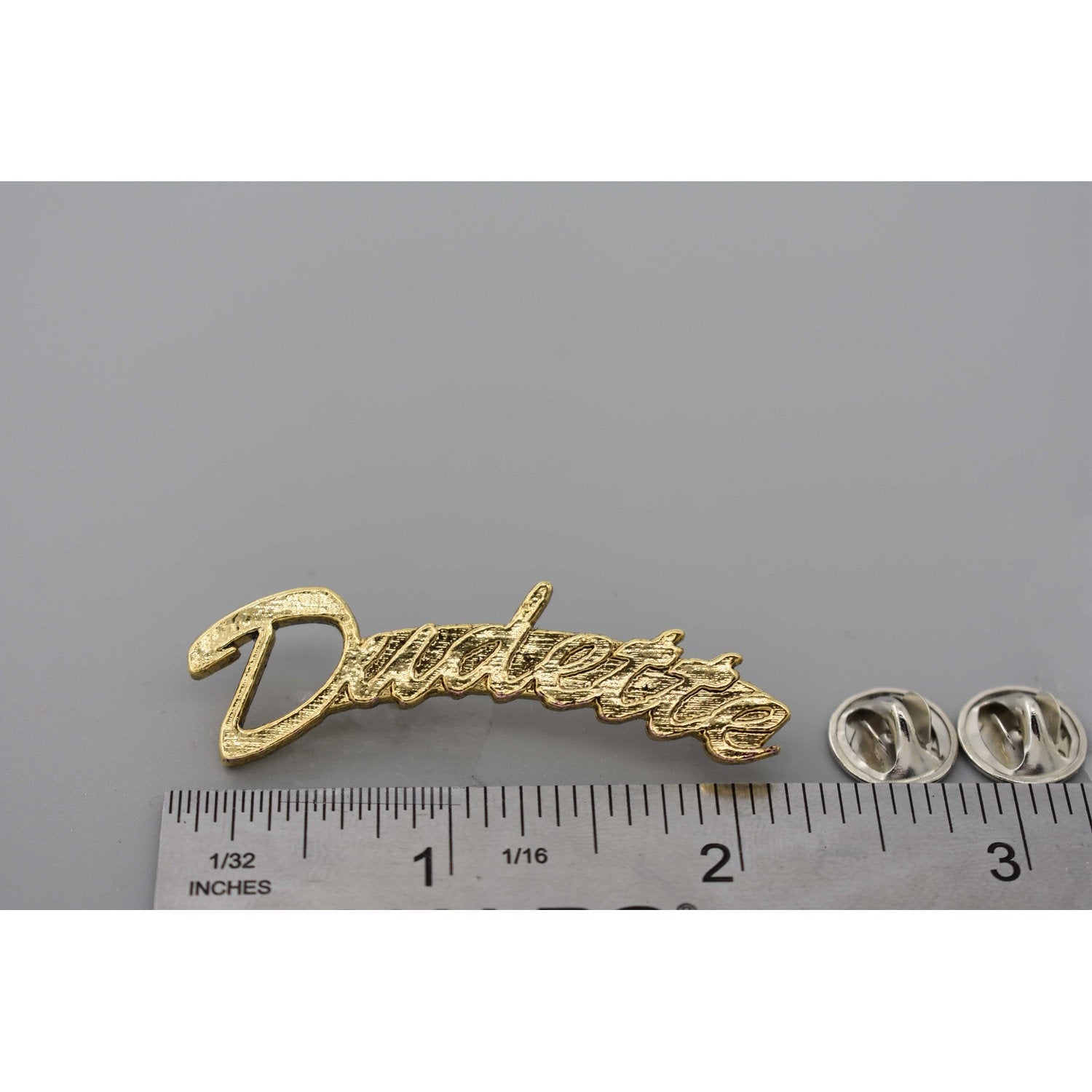 A handcrafted Dudette Pin next to a ruler, available for sale at Creativeartisan.com - the image offers a sense of scale