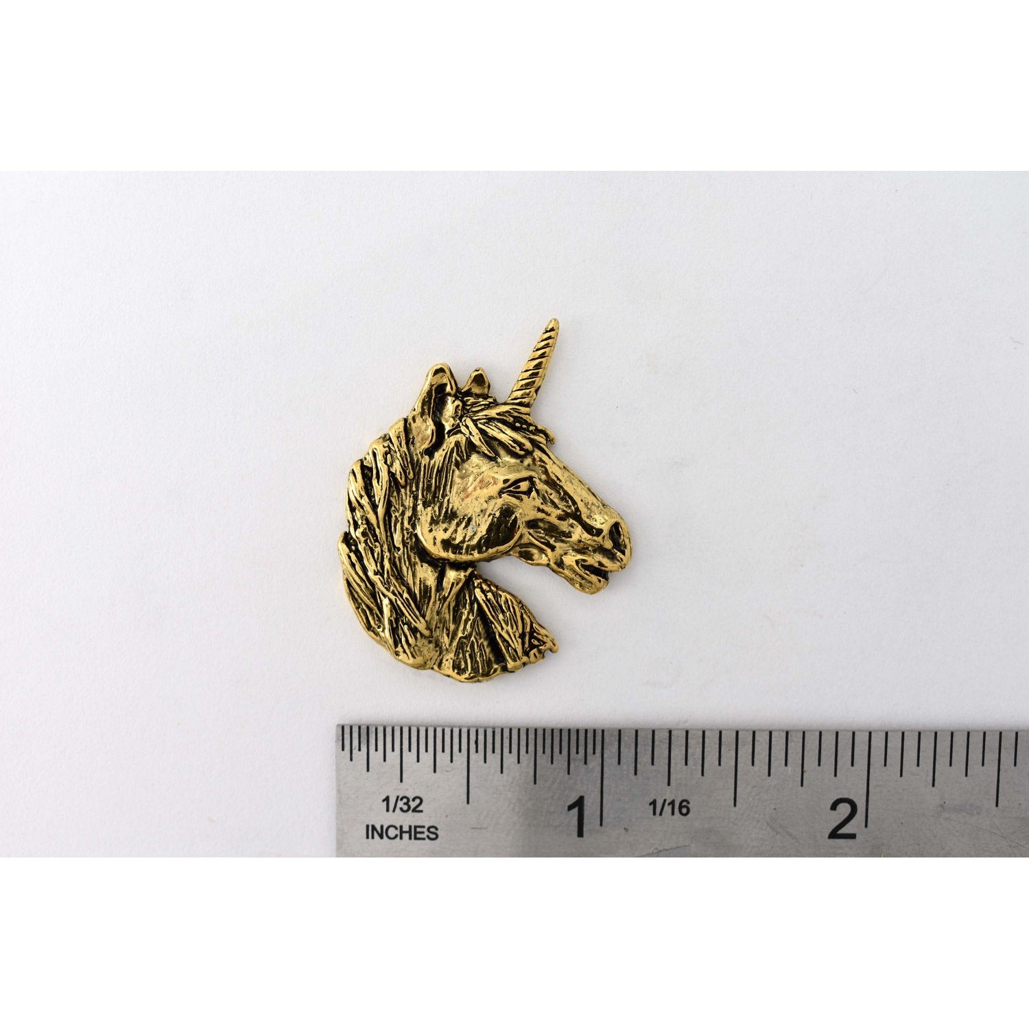 A handcrafted Unicorn Head Pin next to a ruler, available for sale at Creativeartisan.com - the image offers a sense of scale