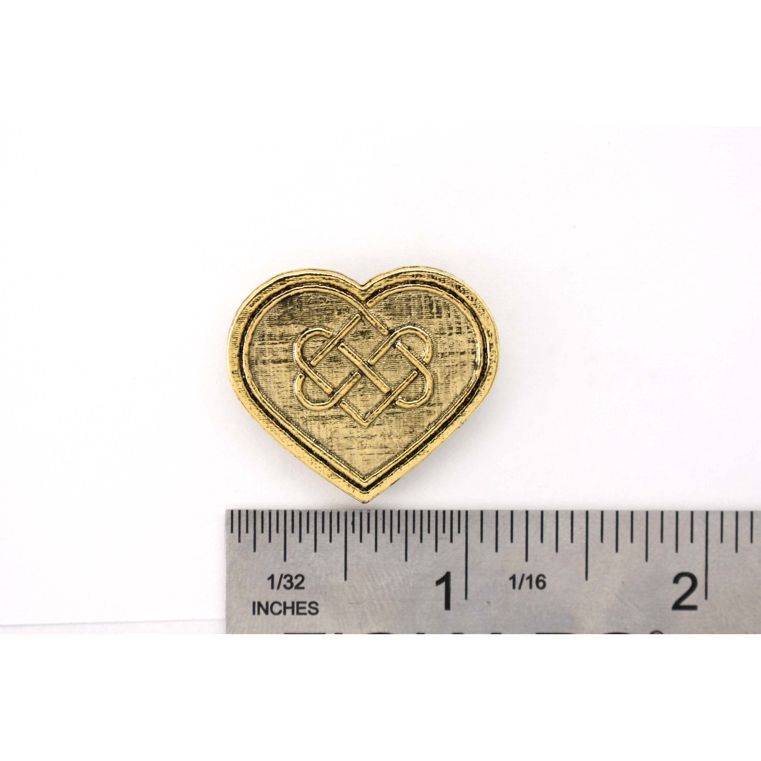 A handcrafted Heart With Celtic Knot Pin next to a ruler, available for sale at Creativeartisan.com - the image offers a sense of scale