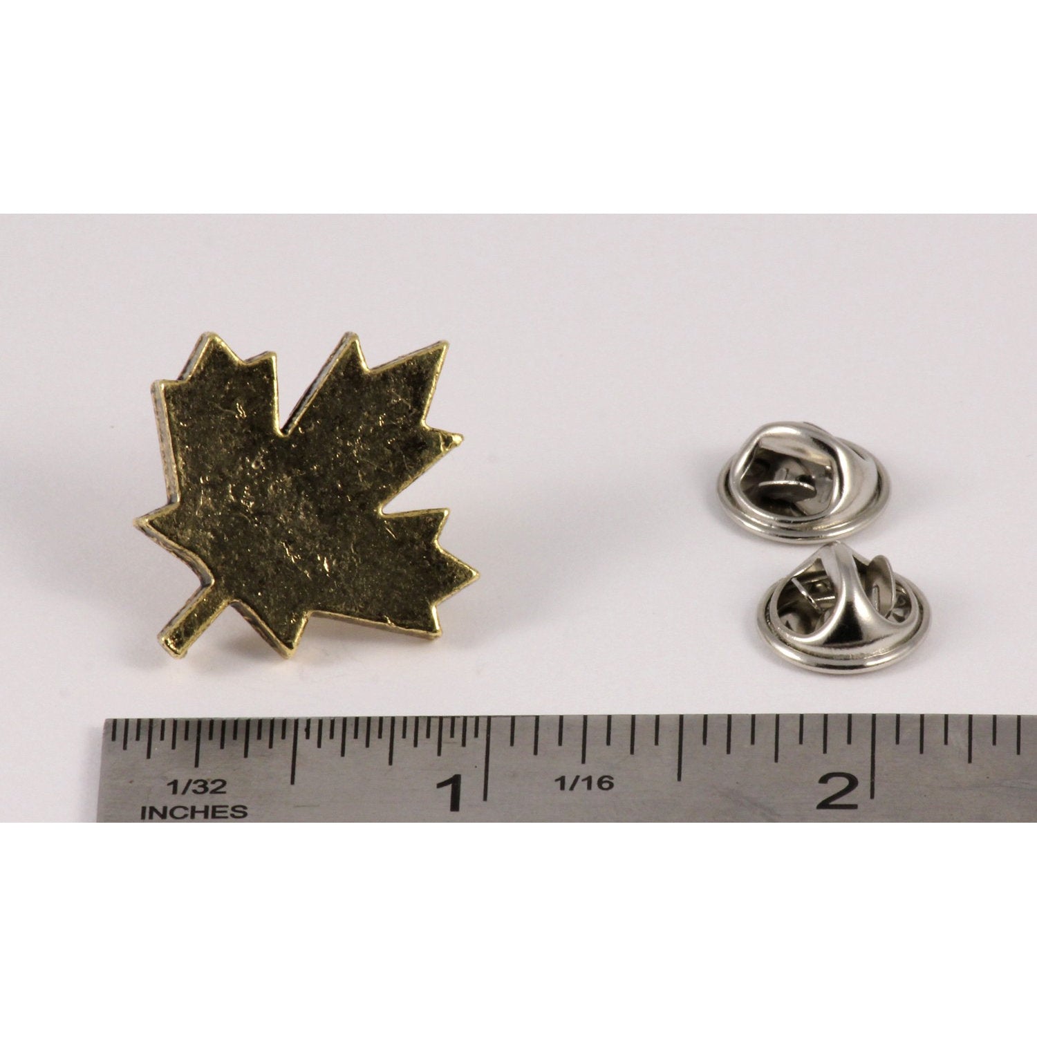 A handcrafted Canadian Maple Leaf Pin next to a ruler, available for sale at Creativeartisan.com - the image offers a sense of scale