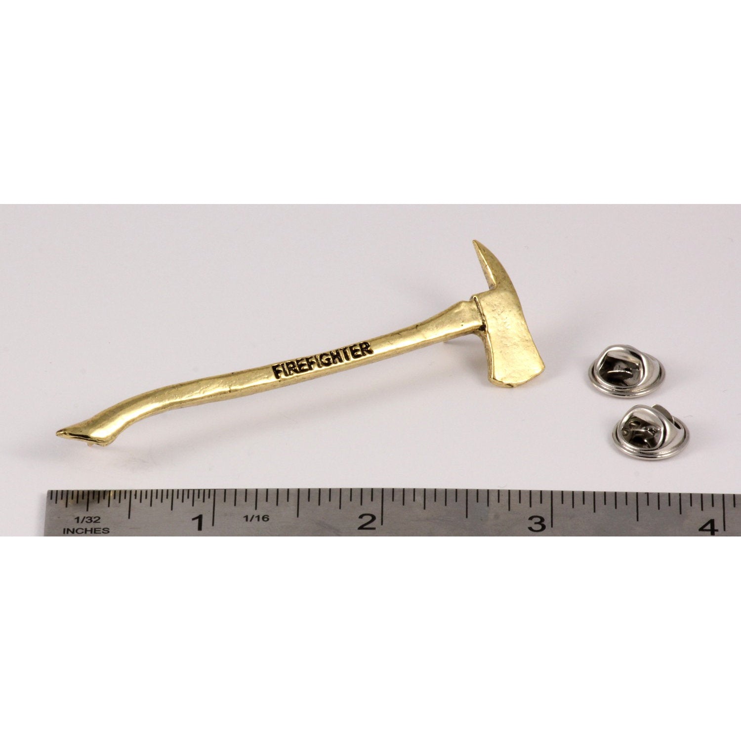 A handcrafted Firemans Axe Firefighter Engraved Pin next to a ruler, available for sale at Creativeartisan.com - the image offers a sense of scale