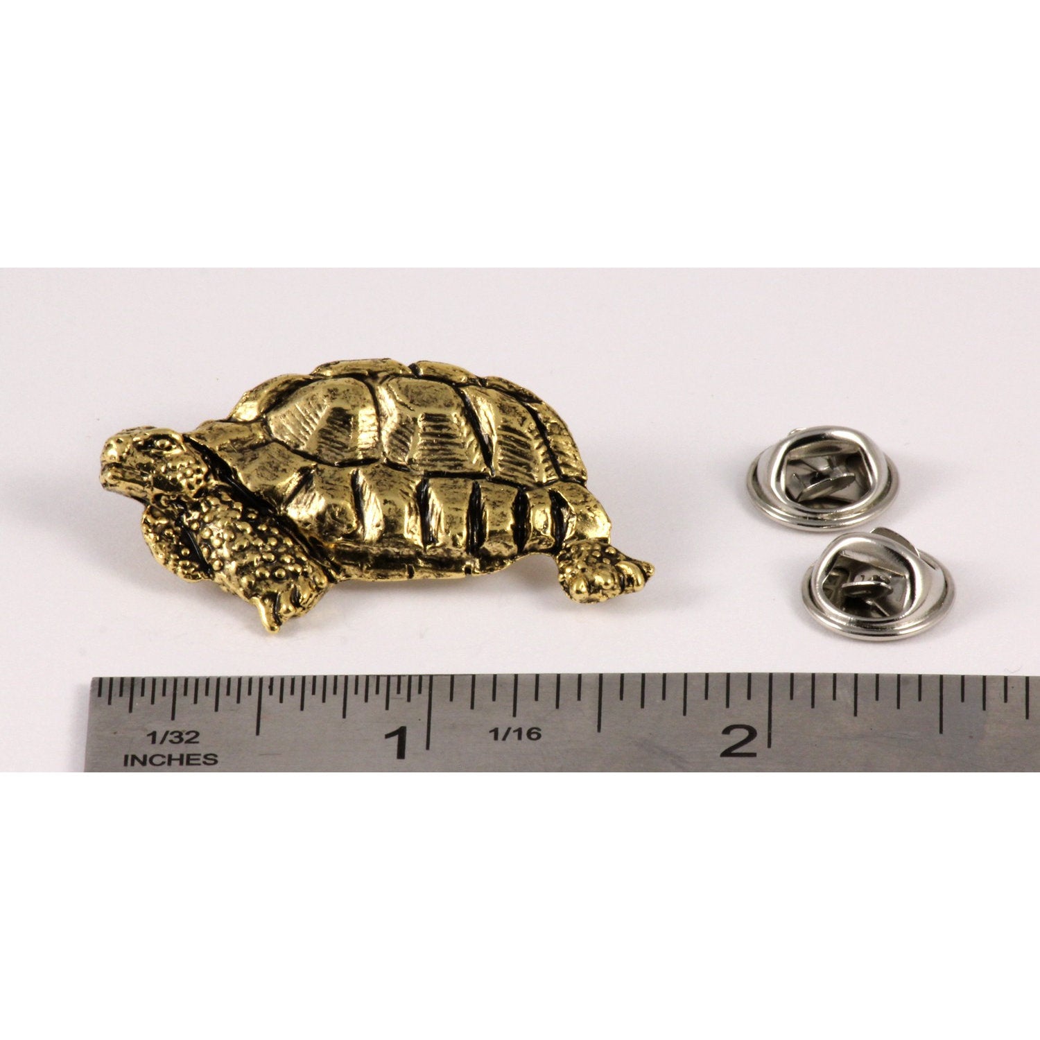 A handcrafted Tortoise Pin next to a ruler, available for sale at Creativeartisan.com - the image offers a sense of scale
