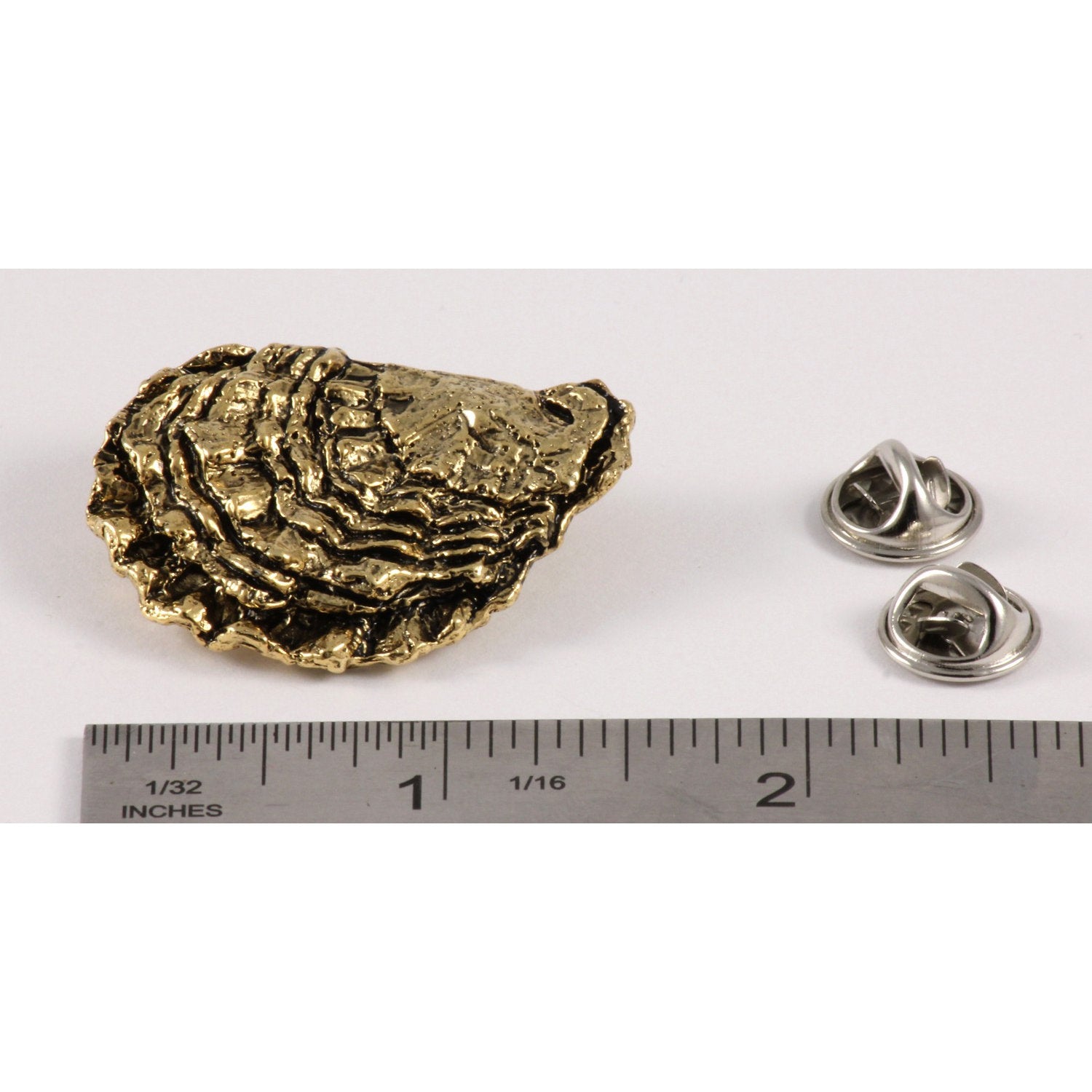 A handcrafted Oyster Shell Pin next to a ruler, available for sale at Creativeartisan.com - the image offers a sense of scale
