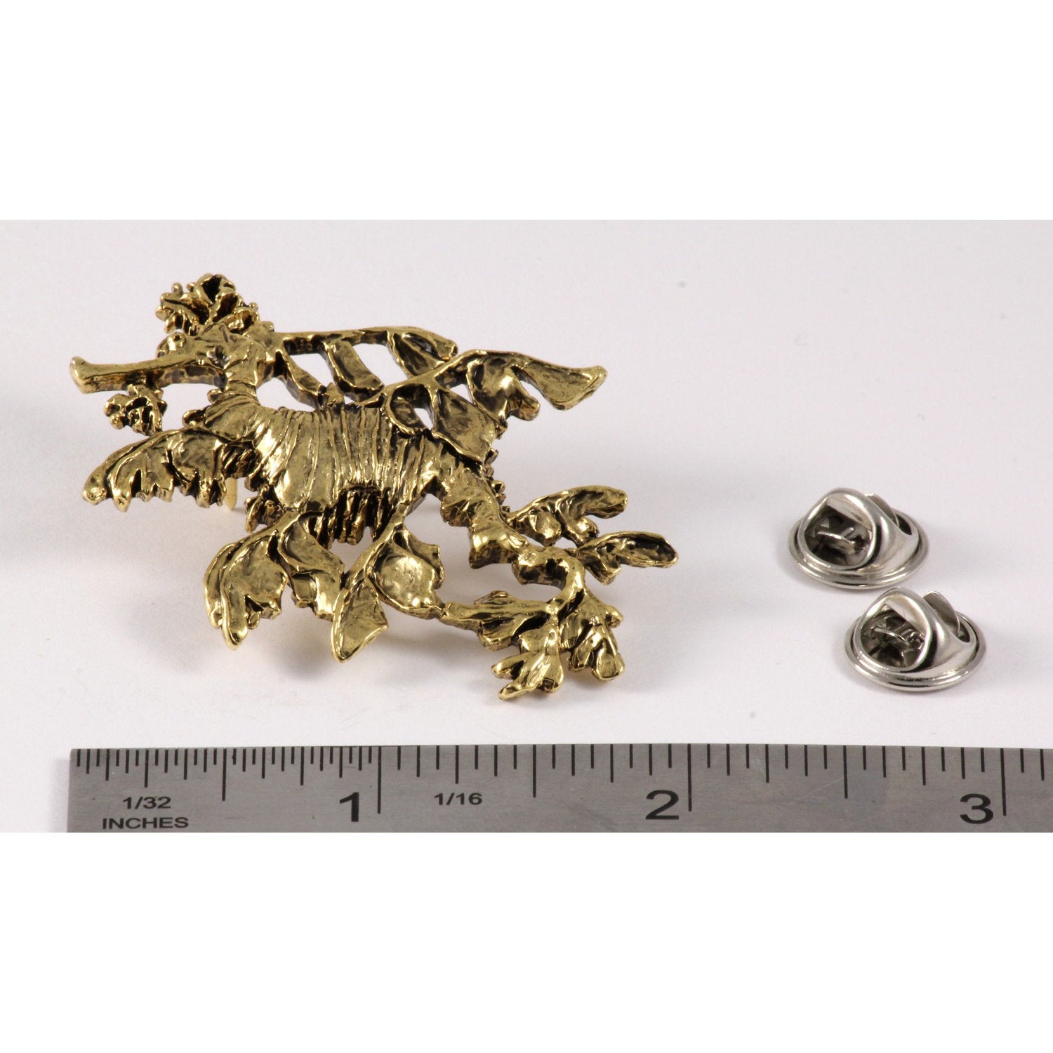 A handcrafted Sea Dragon Leafy Pin next to a ruler, available for sale at Creativeartisan.com - the image offers a sense of scale