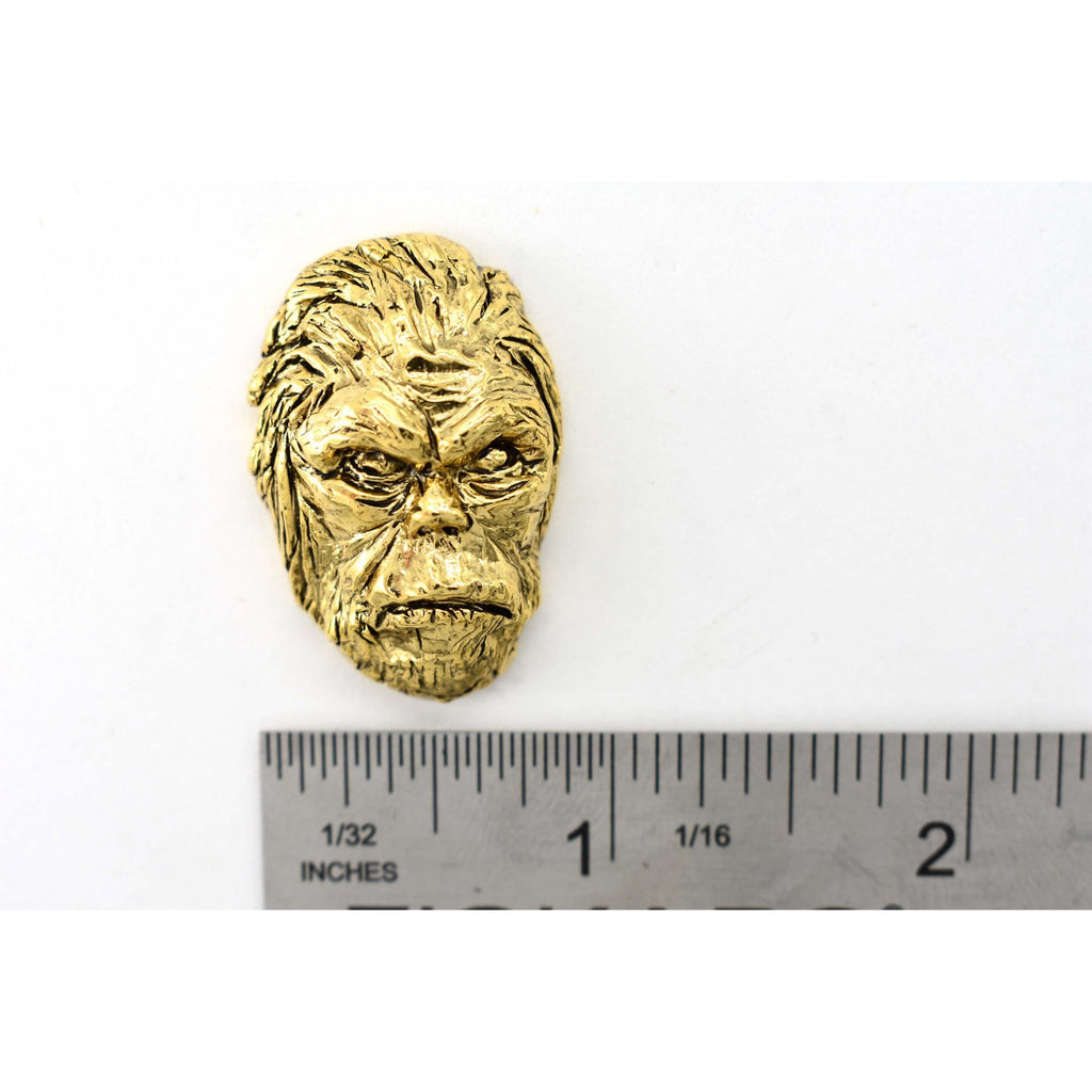 A handcrafted Sasquatch Bigfoot Head Pin next to a ruler, available for sale at Creativeartisan.com - the image offers a sense of scale