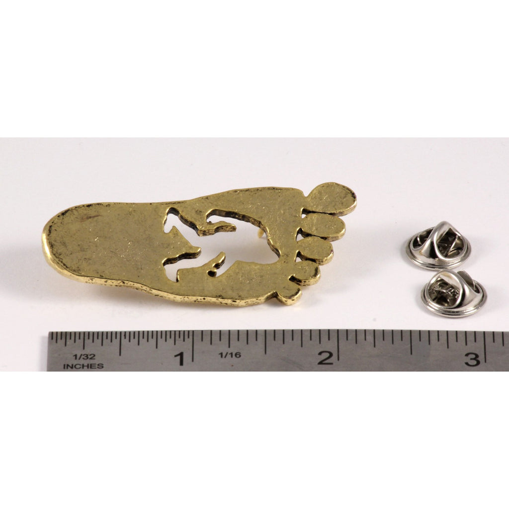 A handcrafted Sasquatch Bigfoot Footprint Pin next to a ruler, available for sale at Creativeartisan.com - the image offers a sense of scale