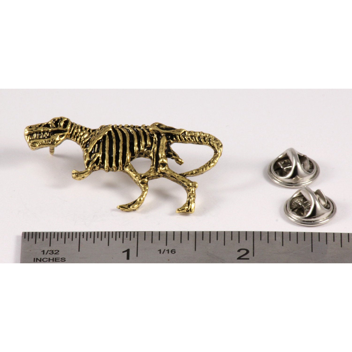 A handcrafted Tyrannosaurus Rex Fossilized Body Pin next to a ruler, available for sale at Creativeartisan.com - the image offers a sense of scale