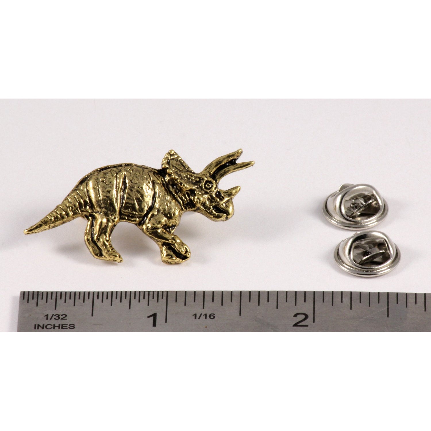 A handcrafted Triceratops Pin next to a ruler, available for sale at Creativeartisan.com - the image offers a sense of scale