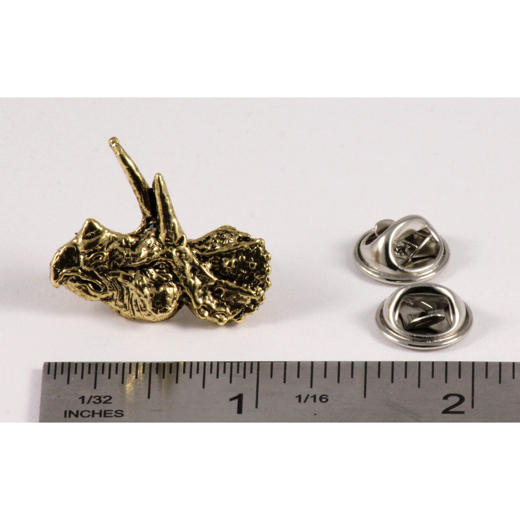 A handcrafted Triceratops Head Pin next to a ruler, available for sale at Creativeartisan.com - the image offers a sense of scale