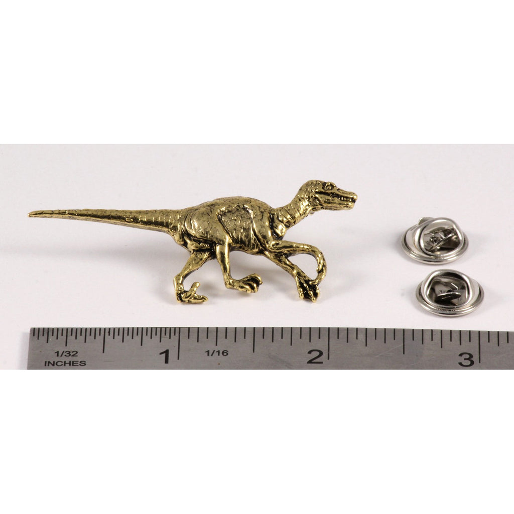 A handcrafted Velociraptor Pin next to a ruler, available for sale at Creativeartisan.com - the image offers a sense of scale