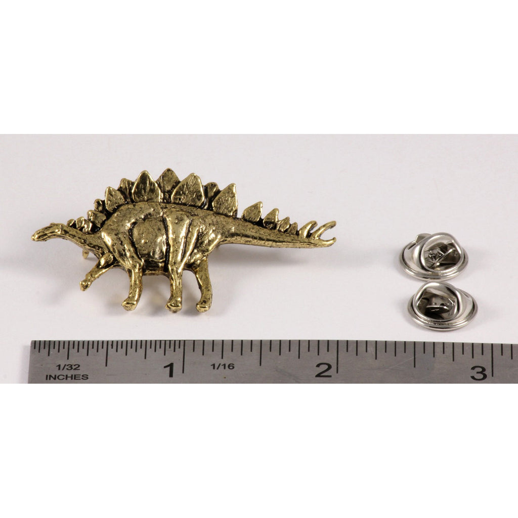 A handcrafted Stegosaurus Pin next to a ruler, available for sale at Creativeartisan.com - the image offers a sense of scale