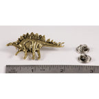 A handcrafted Stegosaurus Pin next to a ruler, available for sale at Creativeartisan.com - the image offers a sense of scale