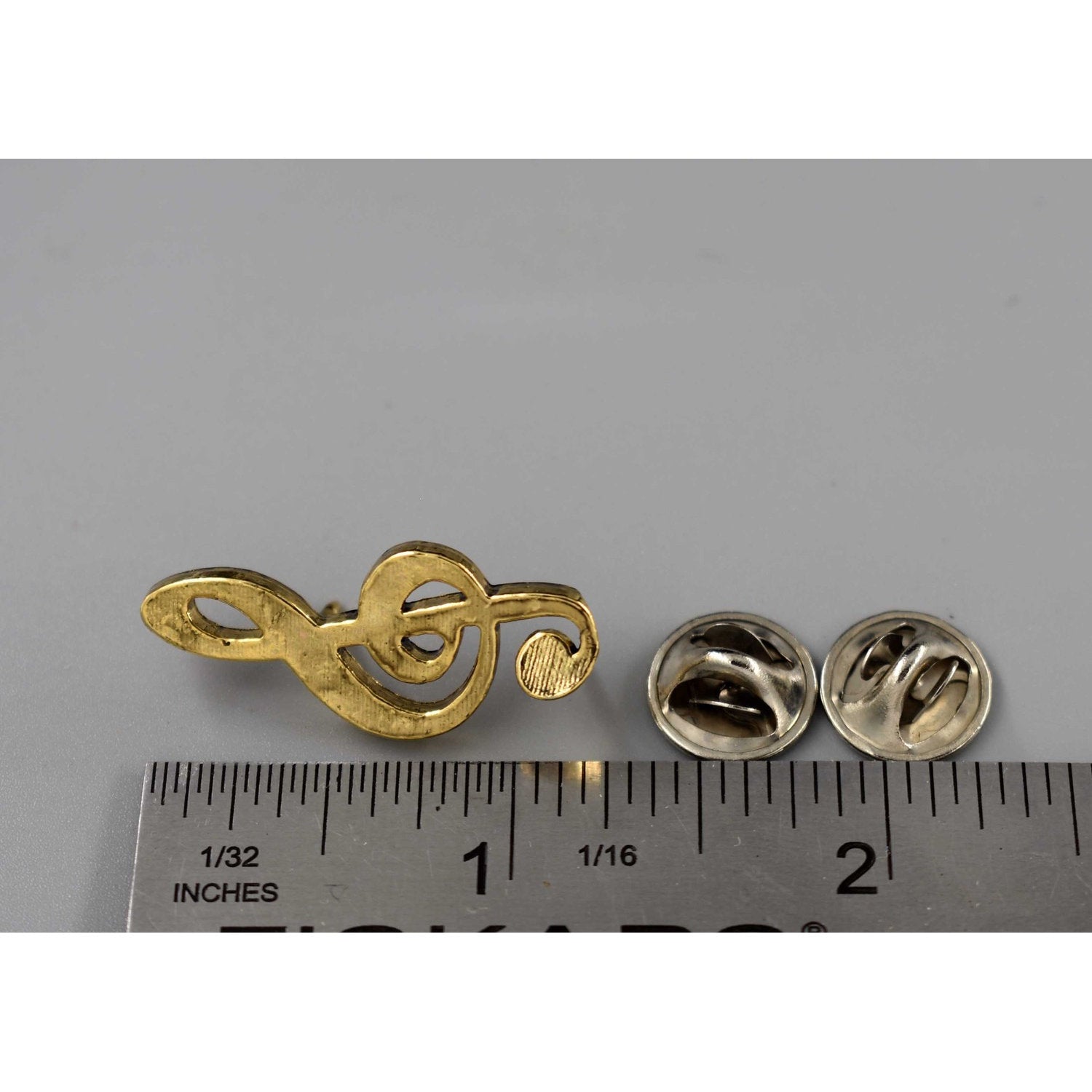 A handcrafted Treble Clef Musical Note Pin next to a ruler, available for sale at Creativeartisan.com - the image offers a sense of scale