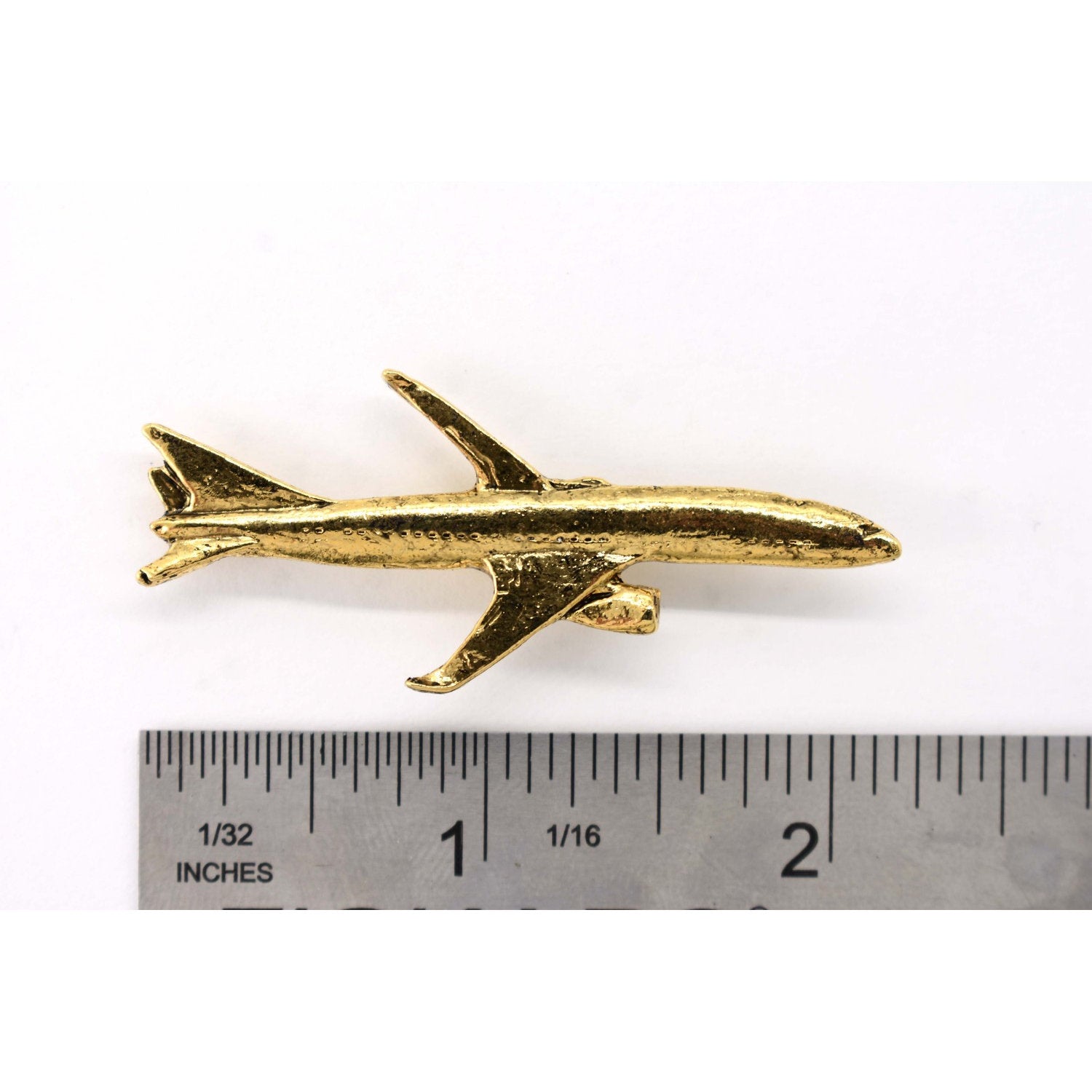 A handcrafted Jetliner Pin next to a ruler, available for sale at Creativeartisan.com - the image offers a sense of scale