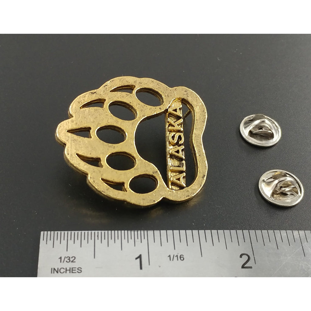 A handcrafted Bear Print Alaska Pin next to a ruler, available for sale at Creativeartisan.com - the image offers a sense of scale