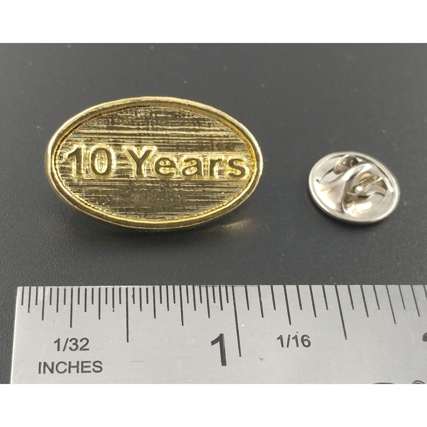 A handcrafted 10 Year Pin next to a ruler, available for sale at Creativeartisan.com - the image offers a sense of scale